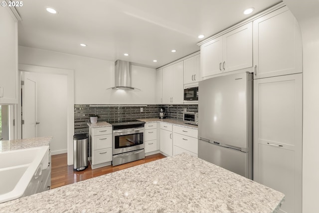 512 NE Division St, Myrtle Creek, OR 97457 - kitchen with freestanding refrigerator, wall chimney exhaust hood, electric range, black microwave, and white cabinetry