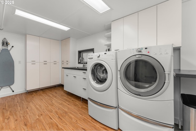 512 NE Division St, Myrtle Creek, OR 97457 - laundry room with cabinet space, washing machine and dryer, and light wood-style flooring