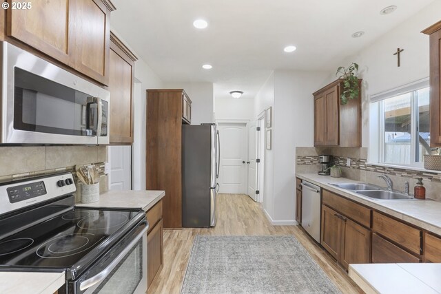 52193 SE Tussing Way, Scappoose, OR 97056 - kitchen with appliances with stainless steel finishes, light wood finished floors, tasteful backsplash, light countertops, and recessed lighting