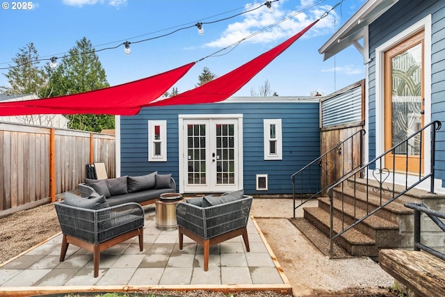 view of patio with french doors, outdoor lounge area, and a fenced backyard