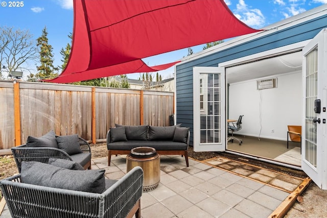 view of patio featuring an outdoor living space, french doors, a fenced backyard, and a wall unit AC