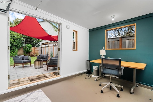 office space featuring a wealth of natural light, baseboards, and concrete flooring