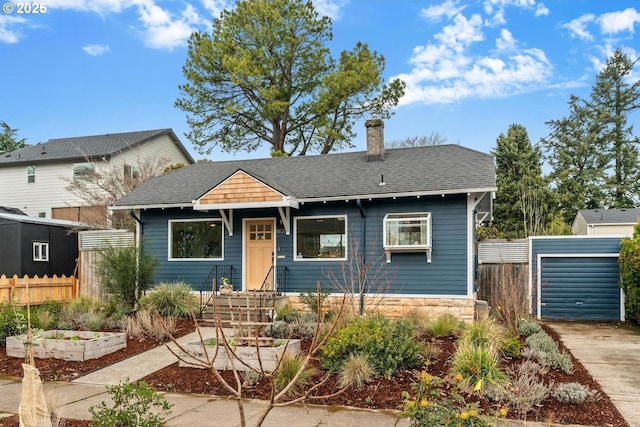 bungalow featuring a vegetable garden, a shingled roof, a chimney, and fence