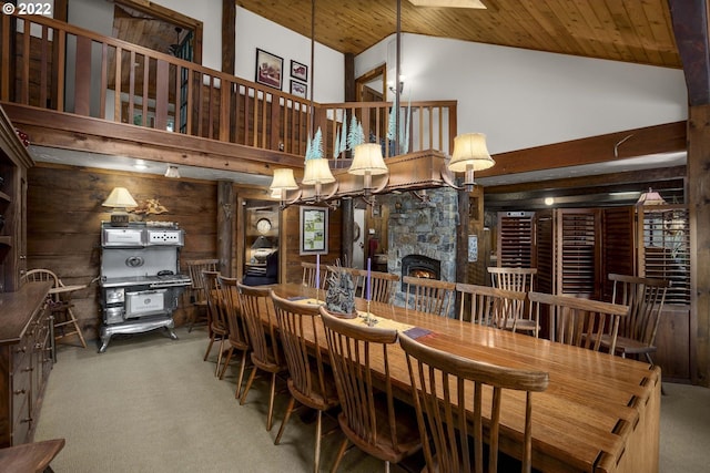 carpeted dining room featuring high vaulted ceiling, wooden ceiling, and a fireplace