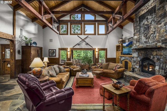 tiled living room featuring wood ceiling, a stone fireplace, high vaulted ceiling, and beamed ceiling