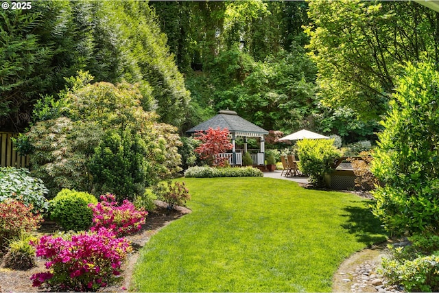 view of green lawn with a gazebo and a patio