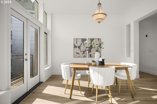 dining space with wood-type flooring and french doors