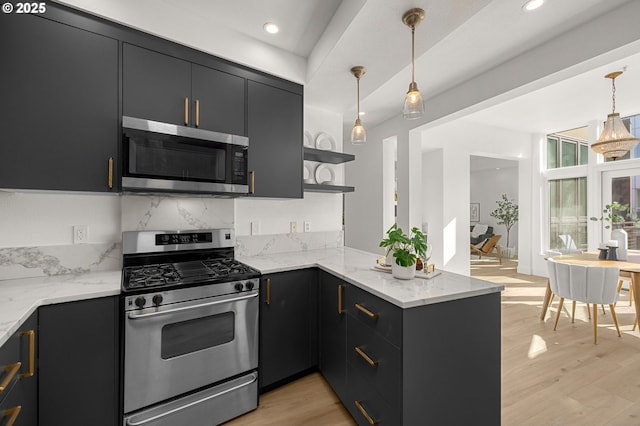 kitchen with pendant lighting, light hardwood / wood-style flooring, light stone counters, kitchen peninsula, and stainless steel appliances