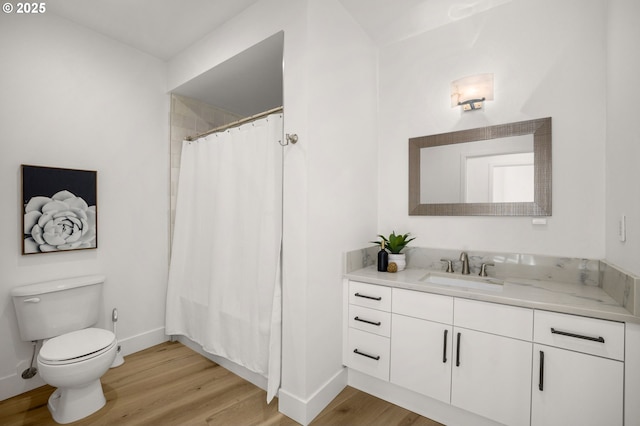 bathroom with hardwood / wood-style floors, vanity, toilet, and walk in shower