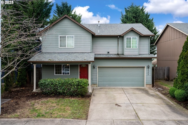 traditional home featuring an attached garage, fence, and driveway