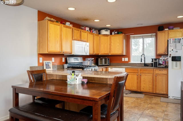 kitchen featuring light tile patterned floors, recessed lighting, a peninsula, white appliances, and a sink