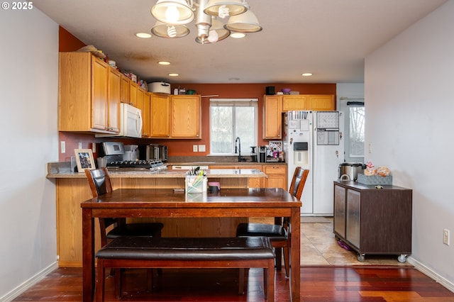 kitchen featuring recessed lighting, white appliances, baseboards, and a peninsula