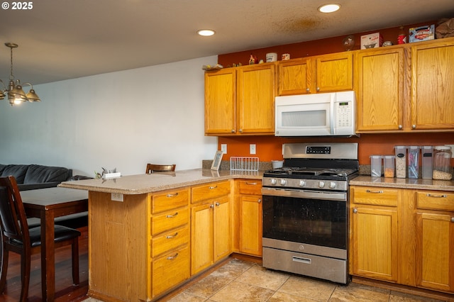 3052 Tierra Dr, Salem, OR 97305 - kitchen featuring white microwave, a peninsula, recessed lighting, stainless steel gas range oven, and open floor plan