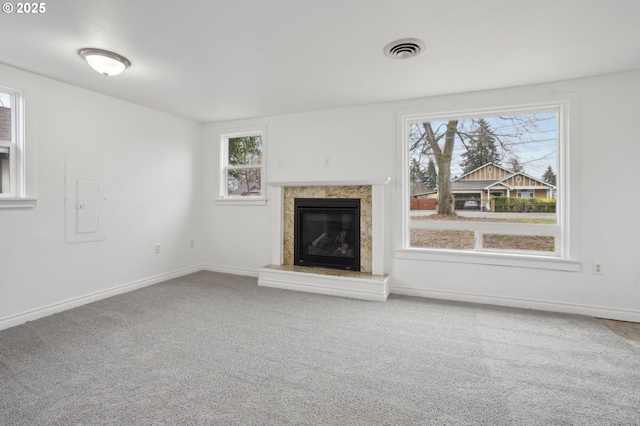 unfurnished living room featuring carpet floors, a fireplace, visible vents, and baseboards