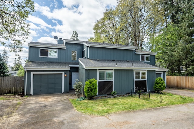 view of front facade featuring a garage, a front lawn, fence, and a shingled roof