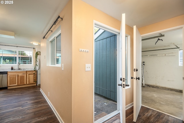 hallway with a sink, baseboards, and dark wood-style floors