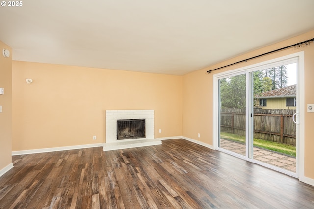 unfurnished living room with baseboards, dark wood-style floors, and a fireplace