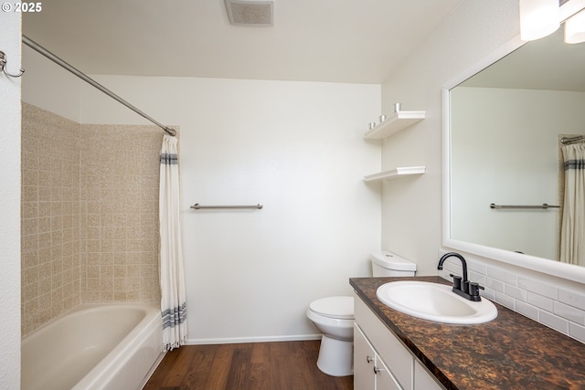 bathroom with vanity, toilet, wood finished floors, shower / tub combo, and visible vents