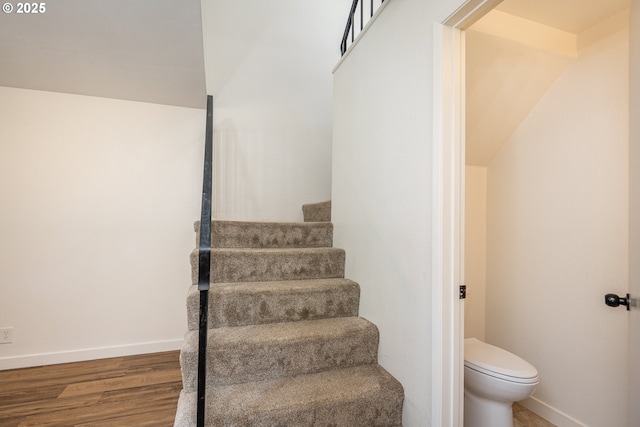 staircase with baseboards and wood finished floors