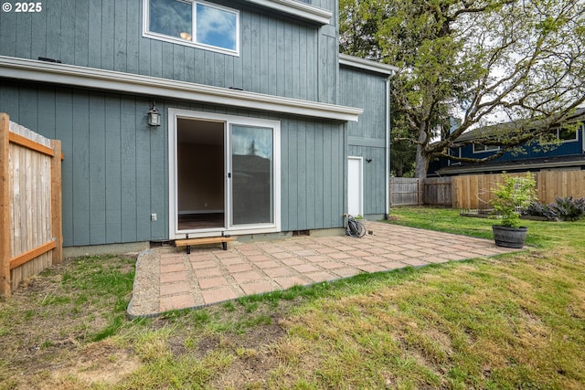 rear view of house with a fenced backyard, a patio, and a yard