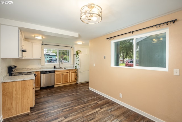 kitchen with a sink, dishwasher, light countertops, freestanding refrigerator, and baseboards