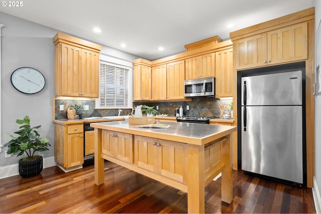 kitchen with tasteful backsplash, light brown cabinets, appliances with stainless steel finishes, dark hardwood / wood-style flooring, and a kitchen island