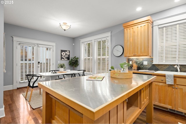 kitchen featuring a kitchen island, dark wood-type flooring, sink, and decorative backsplash