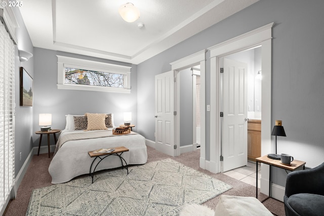 bedroom featuring a raised ceiling and light carpet