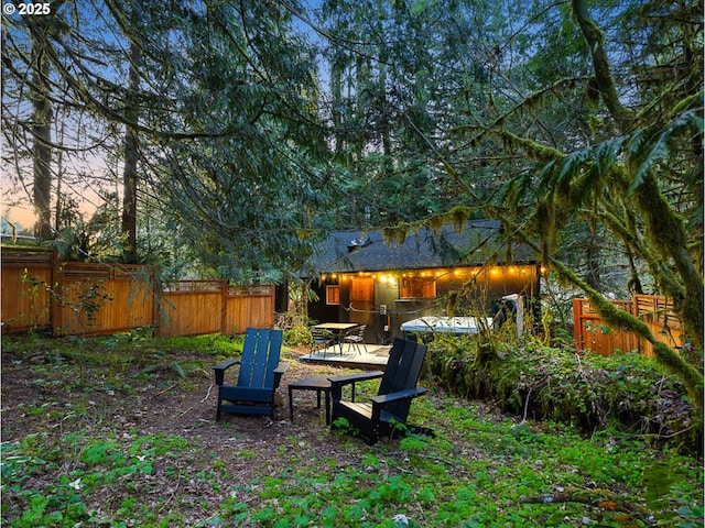 yard at dusk featuring a fenced backyard
