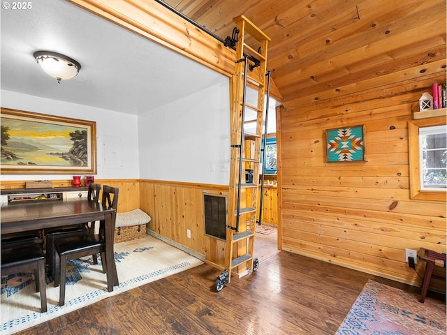 dining area with wainscoting, wood walls, and wood finished floors