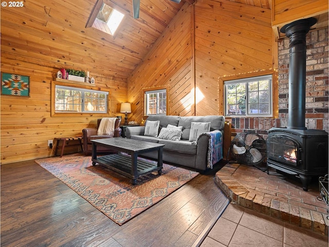 living area featuring wooden walls, high vaulted ceiling, a wood stove, and hardwood / wood-style flooring
