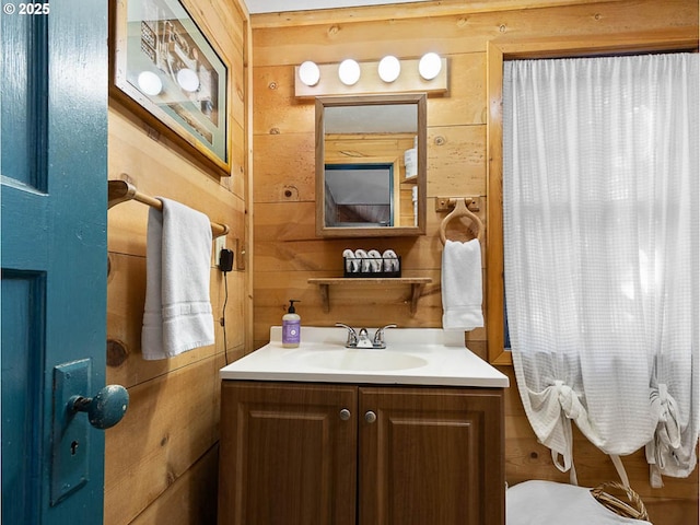bathroom featuring vanity and wooden walls