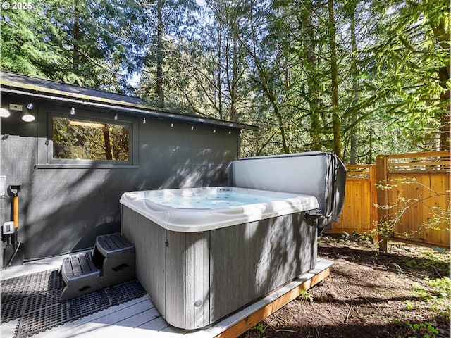 wooden deck featuring a hot tub and fence