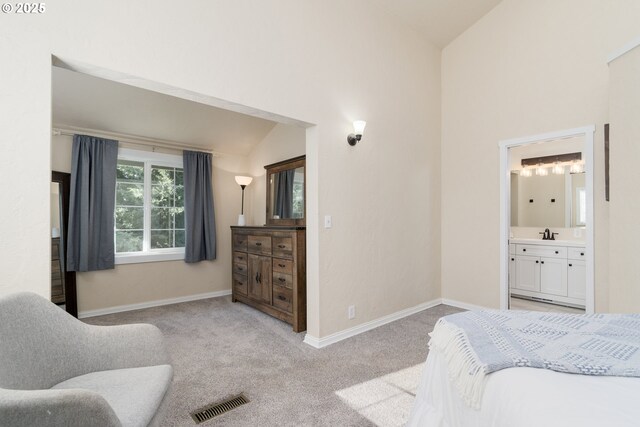 carpeted bedroom with ensuite bath, a closet, and a towering ceiling