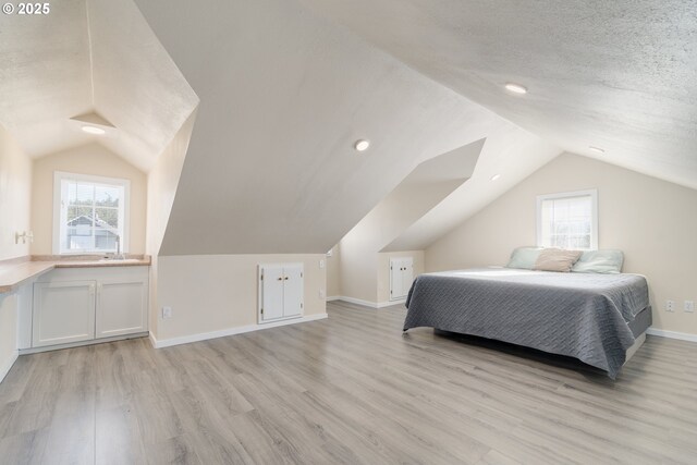 bathroom featuring a washtub, hardwood / wood-style flooring, and vaulted ceiling