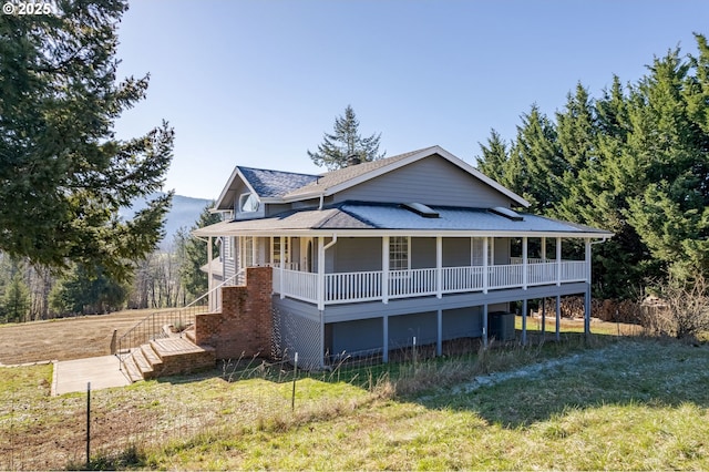 view of front of property with central AC, covered porch, and a front lawn