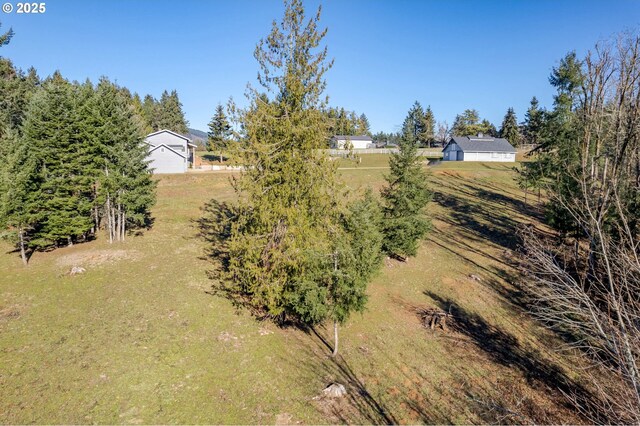 view of yard featuring a rural view and a garage