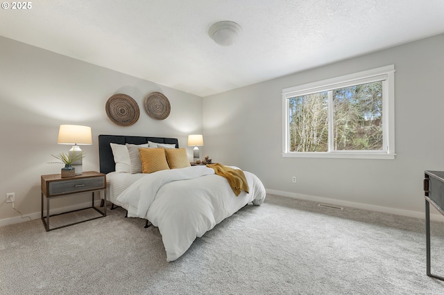 carpeted bedroom featuring visible vents, a textured ceiling, and baseboards