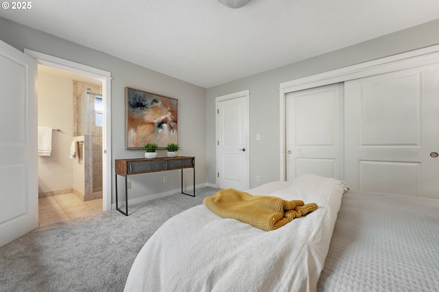 bedroom with a closet, carpet floors, baseboards, and connected bathroom