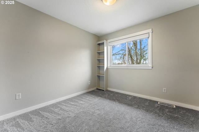 spare room with visible vents, baseboards, and carpet floors