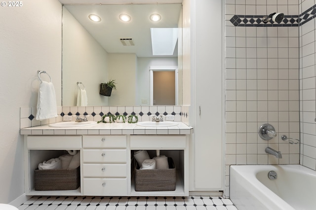 bathroom featuring shower / tub combination, double vanity, visible vents, and a sink