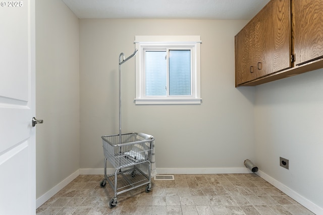 laundry area with visible vents, cabinet space, hookup for an electric dryer, and baseboards