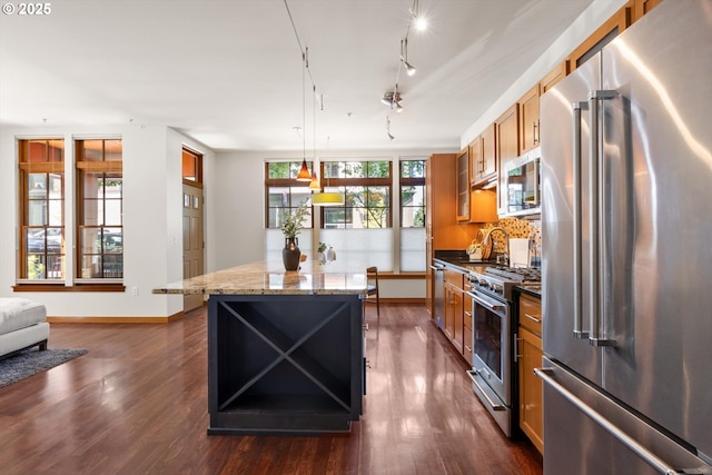2350 NW Savier St Unit 100, Portland, OR 97210 - kitchen featuring high quality appliances, a kitchen island, dark wood-type flooring, and brown cabinets