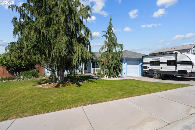 view of property hidden behind natural elements with a front yard, an attached garage, and driveway