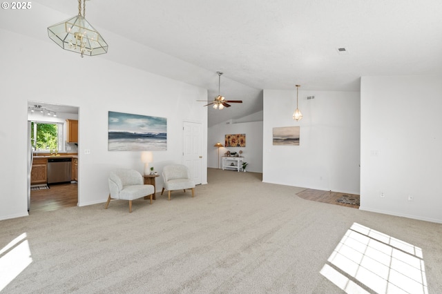 sitting room with light carpet, high vaulted ceiling, ceiling fan, and baseboards