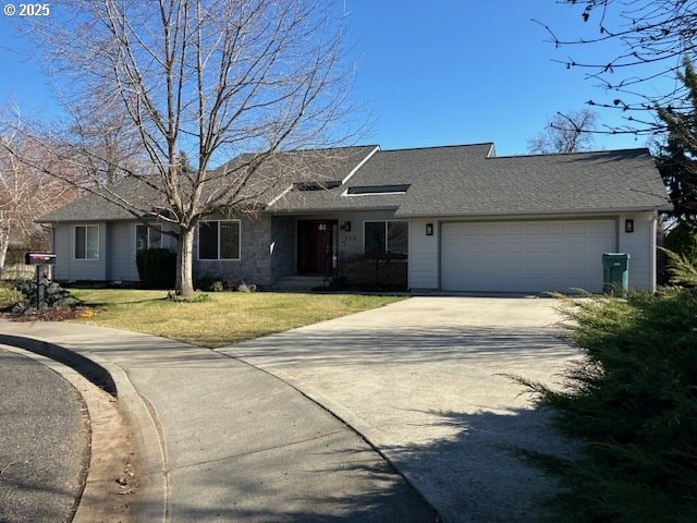 ranch-style house with a front yard, a garage, driveway, and a shingled roof