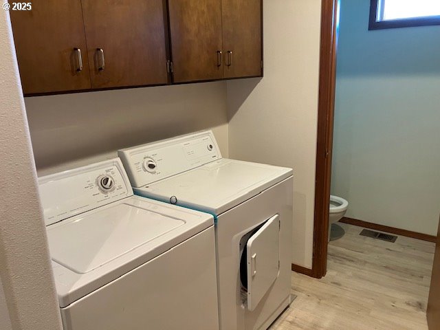 laundry room with visible vents, washing machine and dryer, light wood finished floors, baseboards, and laundry area