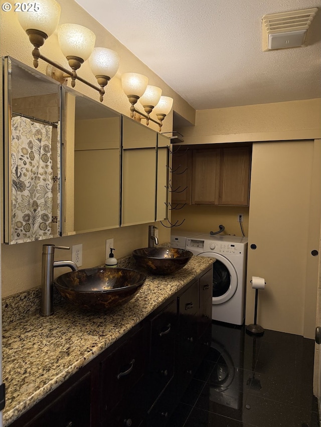 31431 Fairview Rd, Rainier, OR 97048 - bathroom with washer / clothes dryer, double vanity, and a textured ceiling