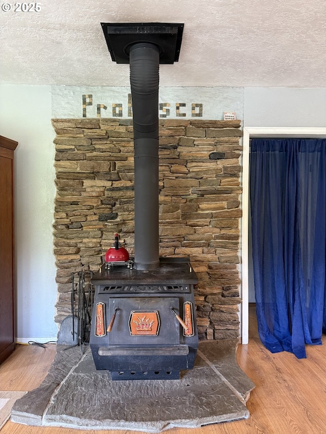 31431 Fairview Rd, Rainier, OR 97048 - detailed view of a wood stove, a textured ceiling, and wood finished floors