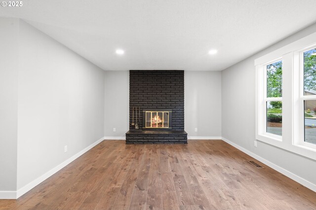 18240 SW Jay St, Beaverton, OR 97003 - unfurnished living room with wood finished floors, a brick fireplace, and recessed lighting